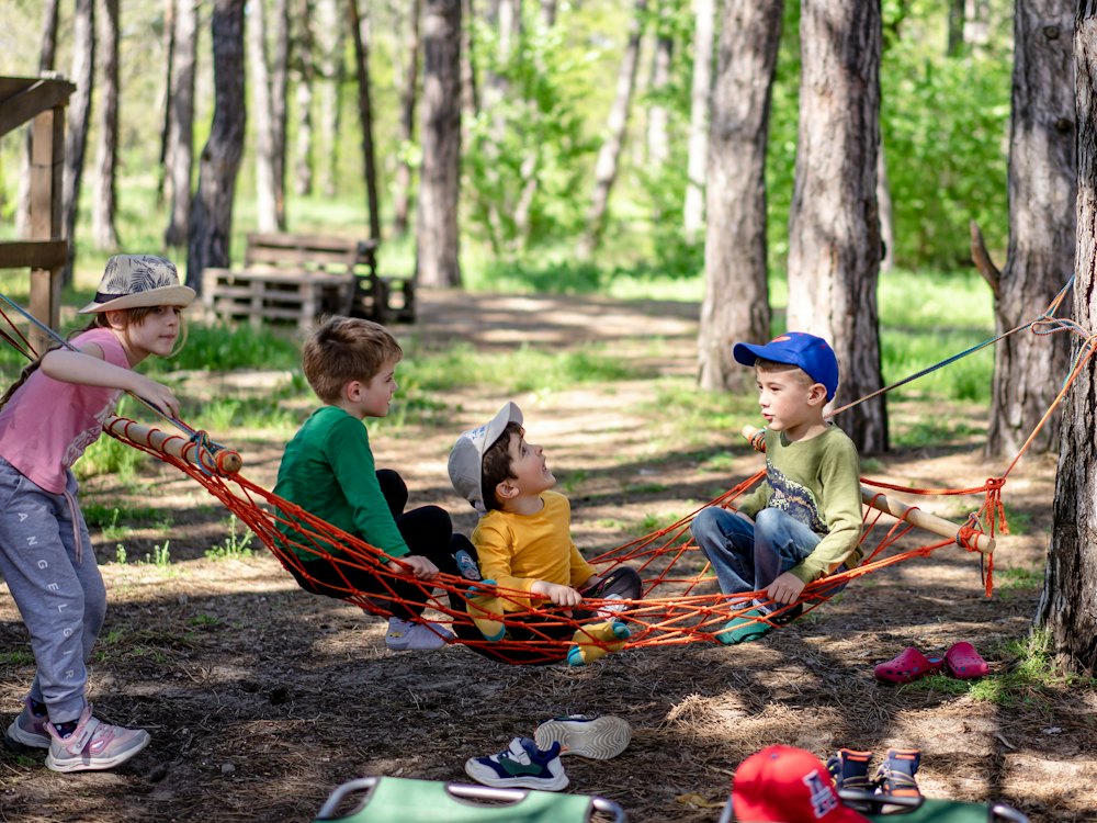 Kids piled into a hammock in the woods