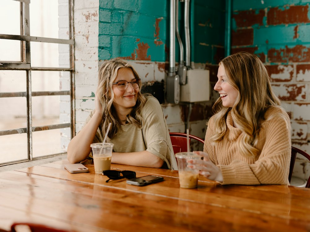 Two women laughing over coffee