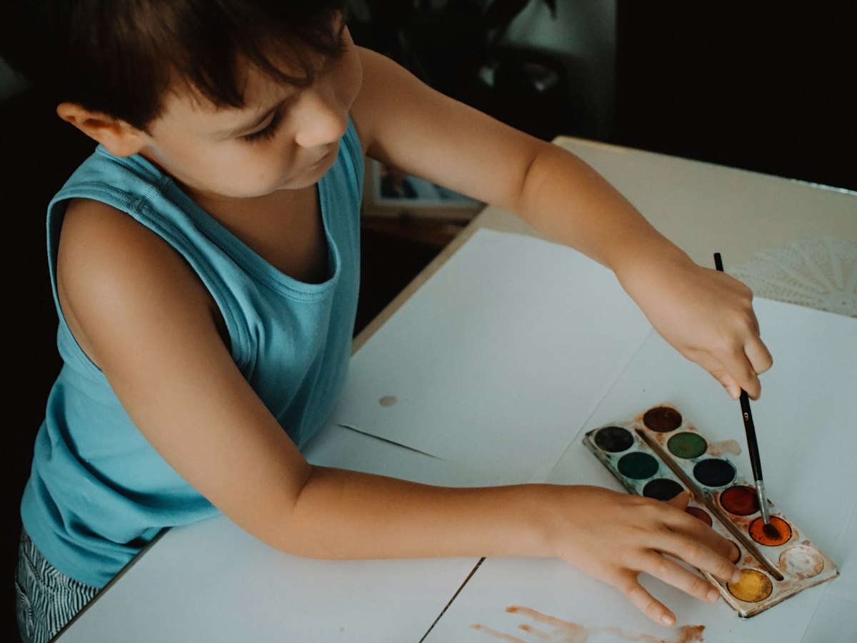 A boy painting with a watercolor set